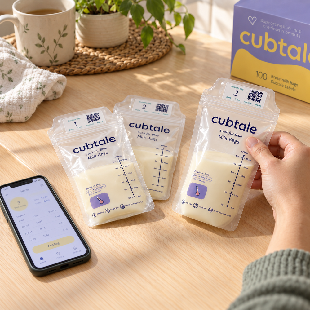 A parent tracking Cubtale QR-labeled milk bags with a phone resting on the table.
